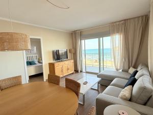 a living room with a couch and a table at Sol, Mar y Terraza XXL frente a la playa in Daimuz