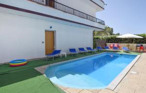 a swimming pool with chairs and an umbrella at Nice Apartment In Palmi With Wifi in Palmi