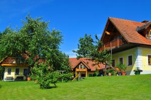 ein Haus auf einem Hügel mit einem grünen Hof in der Unterkunft Haus Schönegger in Kitzeck im Sausal