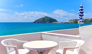 a table and chairs on a balcony overlooking the ocean at Hotel Regina del Mare in Ischia
