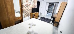 a white bed in a room with a brick wall at Wagners Refuge 3 in Riga