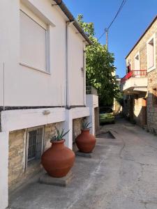 drie grote potten op de zijkant van een gebouw bij Kallimasia Chios - Iraklis House in Kallimasiá