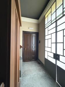 a hallway with a brown door and a window at RoomsCarloFeliceStation in Turin