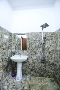 bagno con lavandino e parete in pietra di VS BeachSide Resort a Negombo Altre 56 foto