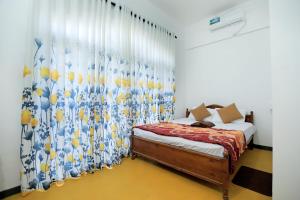 una camera da letto con un letto e una tenda con degli uccelli sopra di VS BeachSide Resort a Negombo