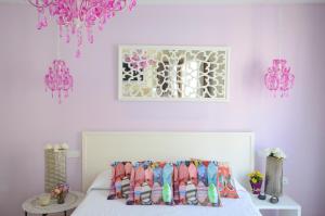 um quarto com paredes cor-de-rosa e uma cama com almofadas em Residencial Terra de Mar, Grupo Terra de Mar, alojamientos con encanto em Calpe