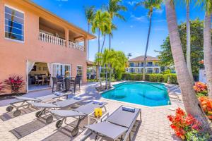 フォート・ローダーデールにあるWalk To Beach Waterfront Heated Pool Pelican Key RESIDENCESのヤシの木が茂るヴィラ