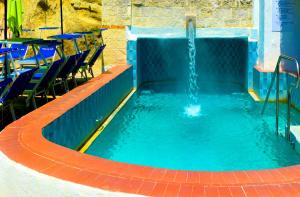a swimming pool with a water fountain at Hotel Regina del Mare in Ischia