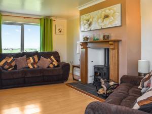 Una sala de estar con dos sofás y una chimenea. en Little Glengyre Farm, en Kirkcolm