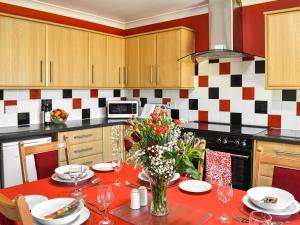 una cocina con una mesa con un jarrón de flores en Little Glengyre Farm, en Kirkcolm 12 fotos más