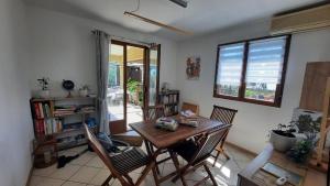 a dining room with a table and chairs and a window at Ylang Ylang in Saint-Leu