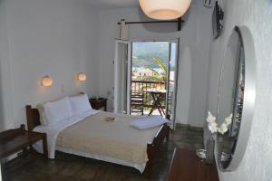 a bedroom with a white bed and white walls at Hotel Anelli in Skopelos Town