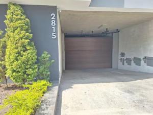 a garage with a garage door and a tree at Departamento en San Isidro in Lima