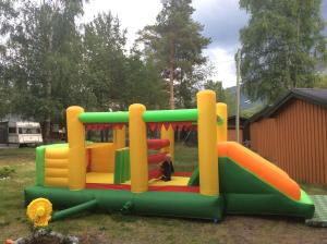 Un parque infantil con un tobogán en un patio en Furuly Camping, en Nordberg