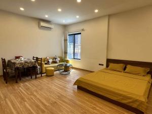 a bedroom with a bed and a table in it at MINGO House BA ĐÌNH in Hanoi