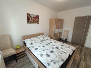 a bedroom with a bed and a chair at Zöld Apartmanház in Balatonboglár +22 photos