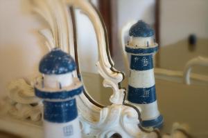 a reflection of a lighthouse in a bathroom mirror at B.E.A. Maison in La Spezia