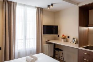 a hotel room with a bed and a desk and a window at Sol St Mande - 2 pers PMR - 30 in Saint-Mandé