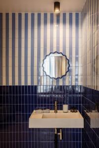 a blue tiled bathroom with a sink and a mirror at Sol St Mande - 2 pers PMR - 30 in Saint-Mandé +11 photos