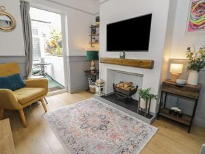a living room with a fireplace and a flat screen tv at Mid Haven Cottage in Conwy