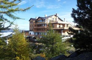 a large apartment building in the middle of trees at Rifugio Orso Bruno in Commezzadura