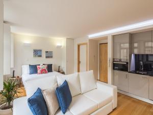 ein Wohnzimmer mit einem weißen Sofa und einer Küche in der Unterkunft InSitu Trindade by Guestify in Porto