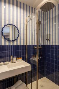 a blue tiled bathroom with a sink and a shower at Sol St Mande - 4 pers- 31 in Saint-Mandé