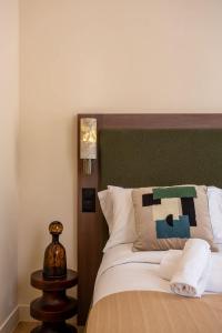 a bed with a green headboard in a room at Sol St Mande - 4 pers- 31 in Saint-Mandé