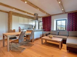 eine Küche und ein Wohnzimmer mit einem Tisch und einem Sofa in der Unterkunft Appartements Pöllhof in Kitzbühel