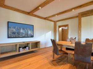 a dining room with a table and a television on a wall at Appartements Pöllhof in Kitzbühel