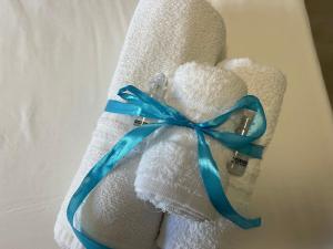 a white towel with a blue ribbon on it at Baleari House in Termoli