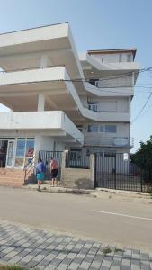 two people standing in front of a building at Villa Mar Bella in Costinesti