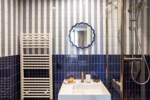 a bathroom with blue and white tiled walls and a sink at Sol St Mande - 2 pers- 32 in Saint-Mandé