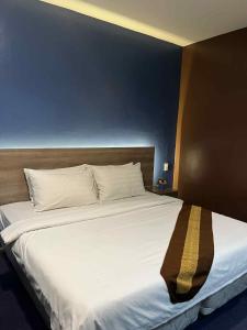 a large bed with white sheets and a wooden headboard at Kojo Hotels Premier in Tagum +15 photos