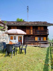 a table and chairs in front of a house at Mayen Farquesses Mayen de Montagne 4 personnes in Evolène