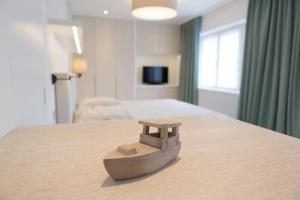 a wooden object sitting on top of a bed at Villa Emilia in De Haan