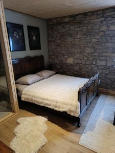 a bed in a room with a stone wall at Au loupus in Durbuy