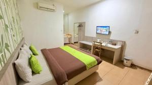 a bedroom with a bed and a bathroom with a sink at Hotel Huswah Airport in Jakarta