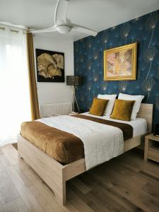 una camera da letto con un letto grande con una parete blu di Les Treilles de Salies - Spa et sauna intérieur a Salies-de-Béarn