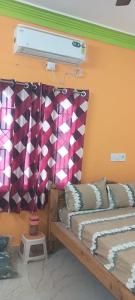 Habitación con 2 camas y una pared con cortinas. en JR Home Stay, en Tiruvannāmalai