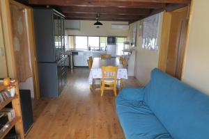 a living room with a blue couch and a kitchen at Guesthouse ONE WORLD 一棟貸の宿 in Kitsuki