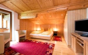 1 dormitorio con 1 cama y TV en una habitación en Tyroler Hof, en Grän