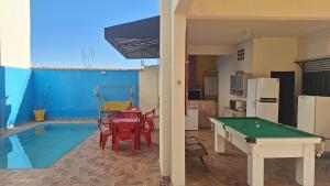 a pool table in a living room next to a swimming pool at Rancho da Nice in Presidente Epitácio