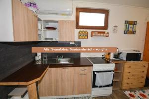 a kitchen with a stove and a counter top at Alíz nyaralóház in Balatonalmádi