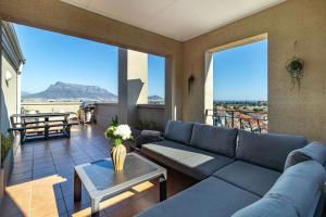 a living room with a couch and a table at 2 Bedroom, Mountain View Penthouse, Century City in Cape Town