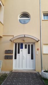 a building with a white door with a window at Apartments Glibo in Cres