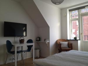 a bedroom with a bed and a desk and a tv at Sweethome Guesthouse in Esbjerg