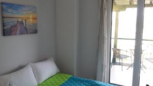 a room with a bed with a painting on the wall at Dasea Houses in Ormos Panagias