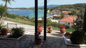 a view of the ocean from a balcony with flower pots at Dasea Houses in Ormos Panagias