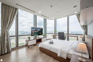 a bedroom with a bed and a tv and large windows at The Luxe Nest Riverside - Vinhome Landmark 81 in Ho Chi Minh City +99 photos
